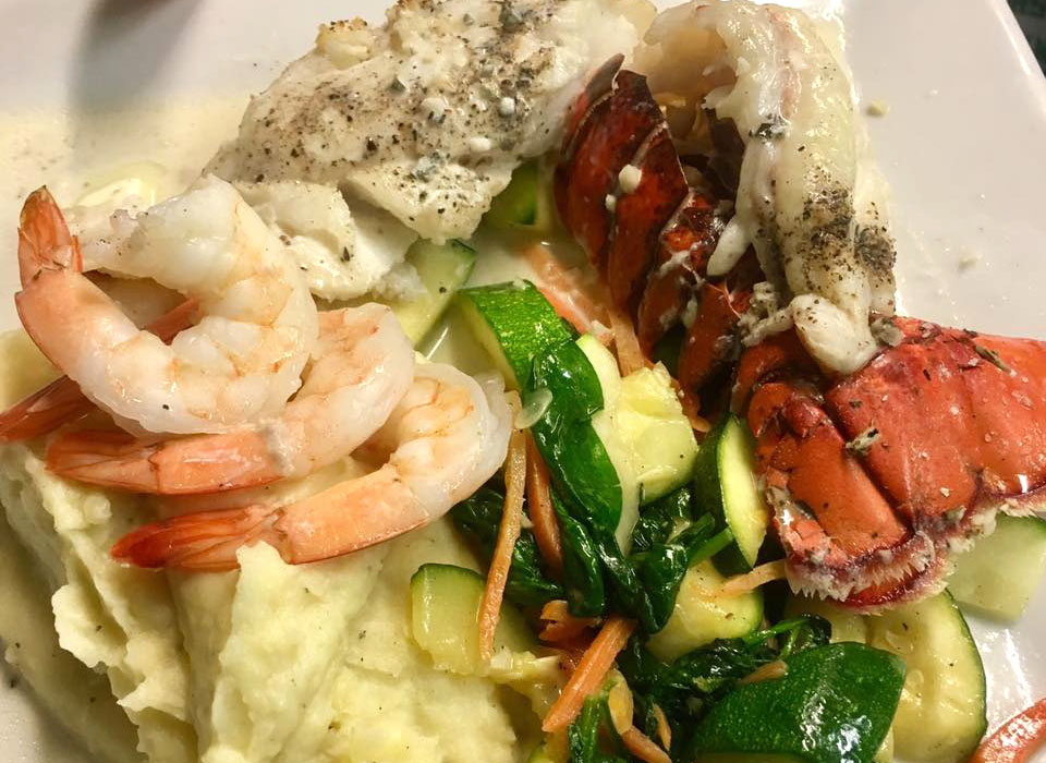 We offer several fish and seafood options including fish or shrimp tacos, fish and chips, grilled salmon, ravioli with shrimp, and shrimp scampi.